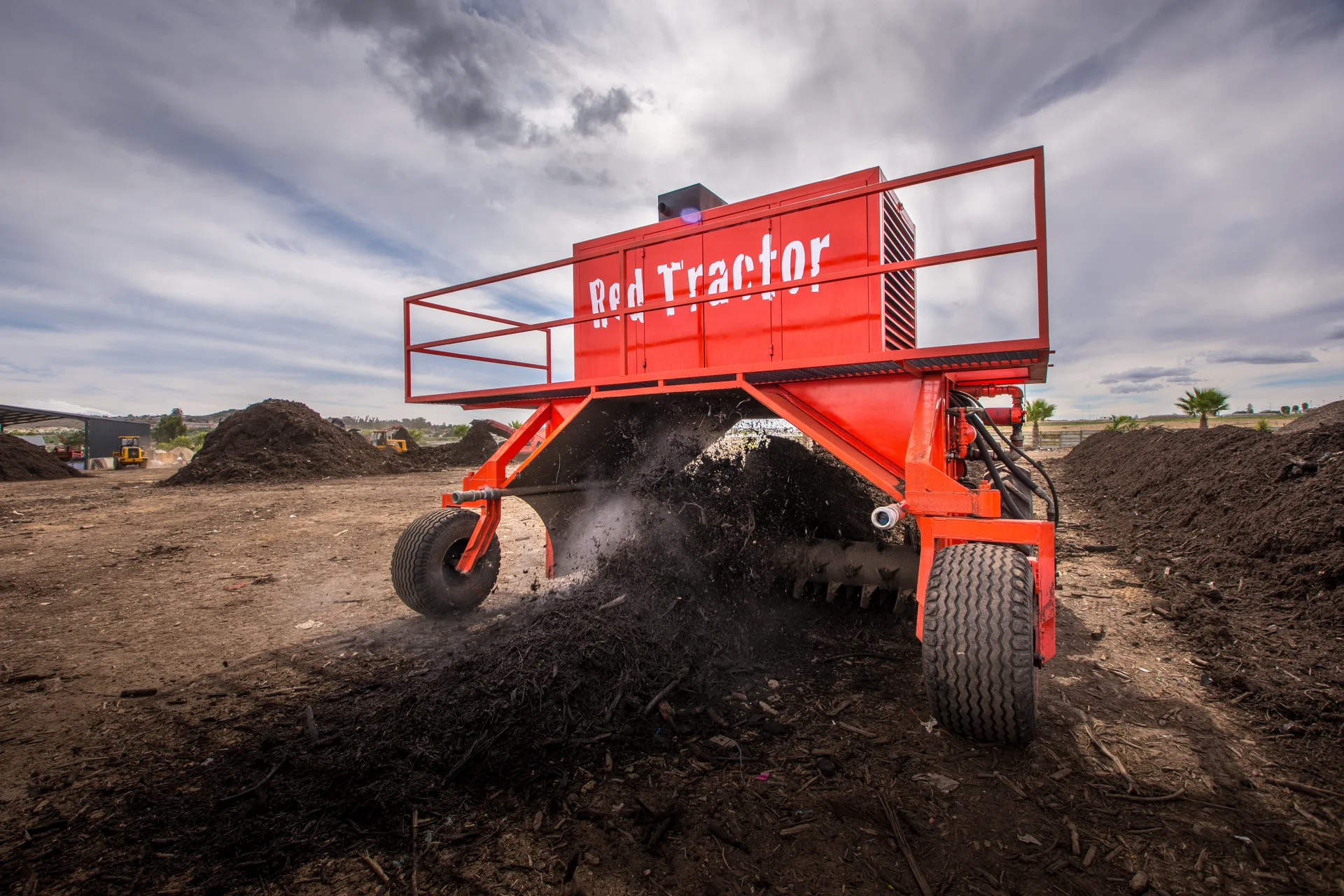 Red Tractor compost turner working through a windrow